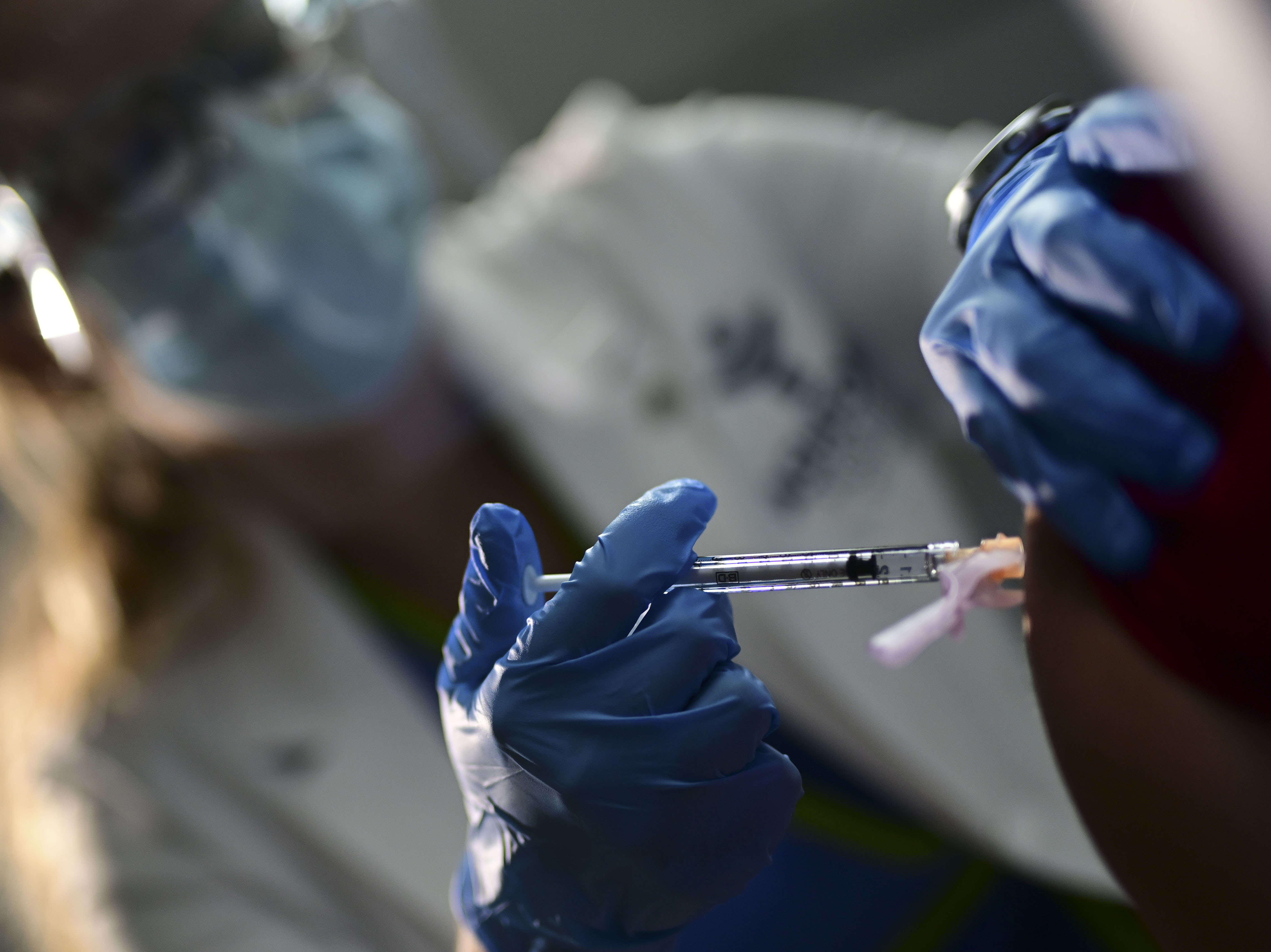 caption: Nurse Melissa Valentin applies the Pfizer-BioNTech COVID-19 vaccine to a health worker at the Ashford Presbyterian Community Hospital in San Juan, Puerto Rico, Tuesday. The vaccine was granted emergency use authorization last week.