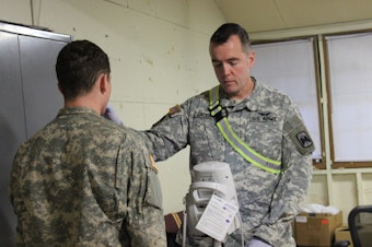 caption: Maj. Dr. Eric Jacobson checks the temperature of a soldier in the controlled monitoring area of Joint Base Lewis-McChord on the morning of Jan. 13, 2015. It was day 13 of the 21-day Ebola monitoring period for the cohort that returned from Liberia. 