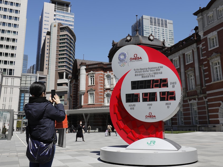 caption: The Tokyo Summer Olympics are being postponed until next year, the International Olympic Committee said Tuesday. Here, a person in Tokyo takes a photo of a clock counting down the days until the planned start of the Tokyo Games.