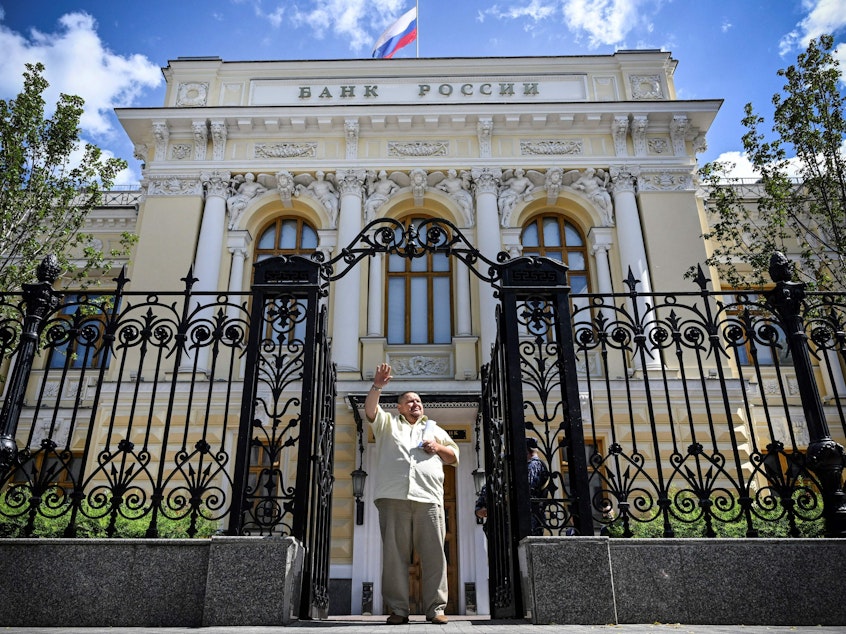 caption: A man waves to a taxi as he leaves the Russian Central Bank headquarters in downtown Moscow last summer. The EU approved a plan this week to use interest from hundreds of billions of dollars' worth of seized Russian assets to help fund Ukraine's military.