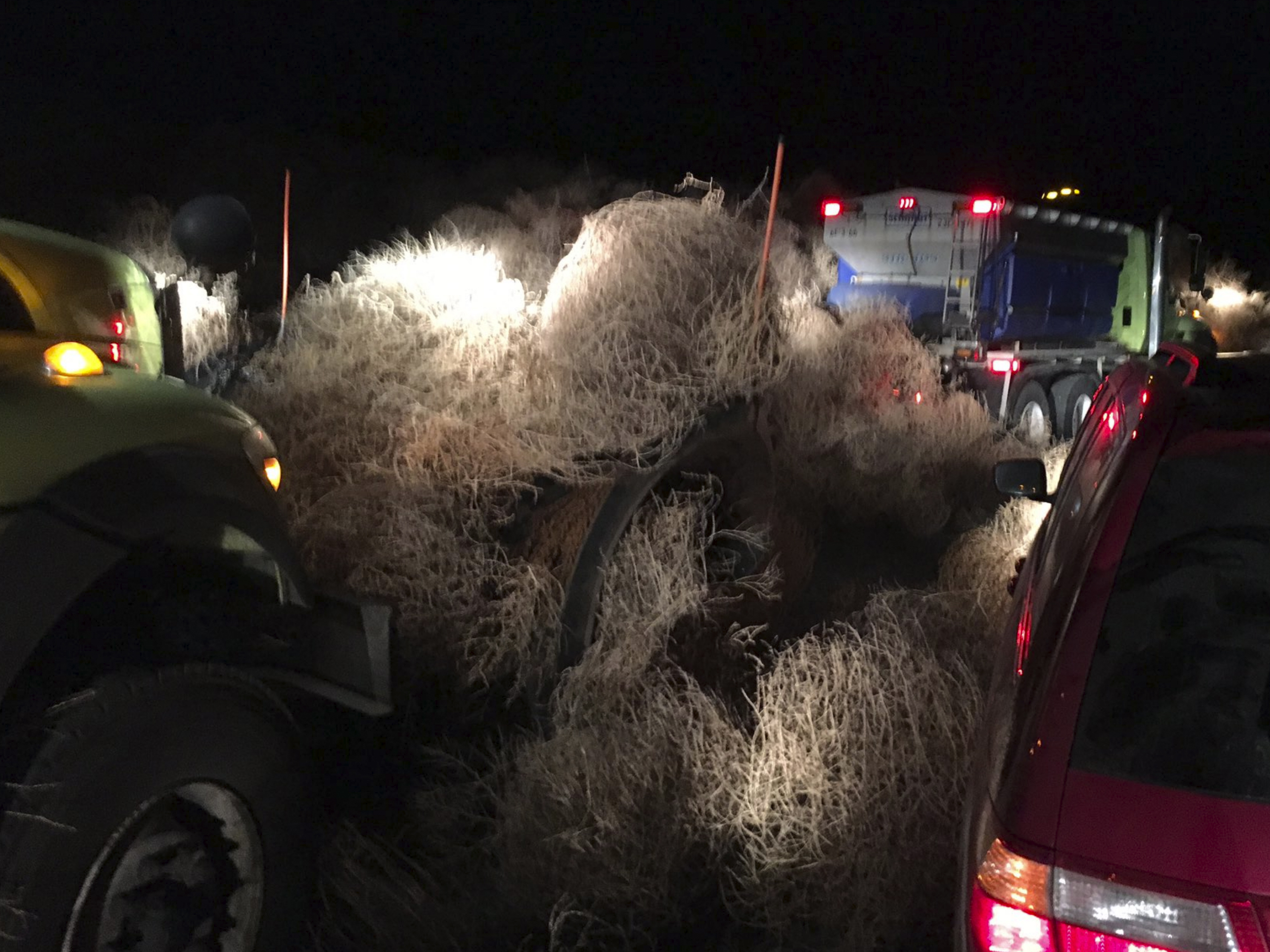 caption: The Washington State Department of Transportation used snow plows Tuesday evening to remove a pile of tumbleweeds along State Route 240 near Richland.