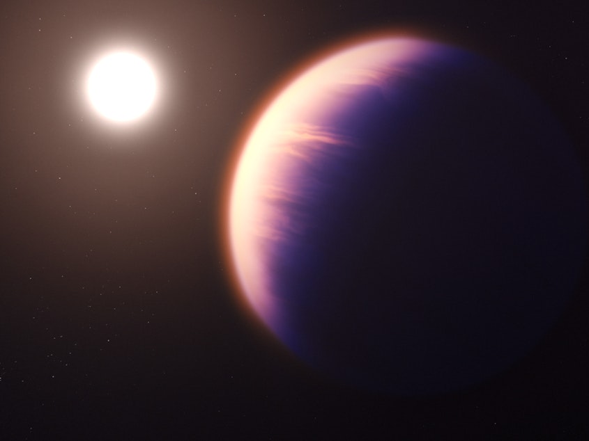 caption: This illustration shows how the gas giant planet WASP-39 b might look as it orbits its host star.