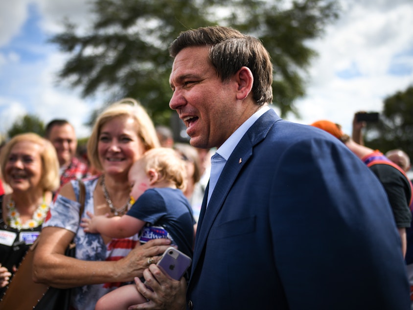 caption: Ron DeSantis meets with supporters at a rally Monday in Orlando, Fla.