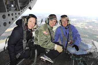 caption: From left, U.S. Sen. Maria Cantwell, former Gov. Chris Gregoire and U.S. Sen. Patty Murray at the back of a helicopter overlooking a flood zone in Washington state. Story goes that only the women in the WA delegation were brave enough to scoot this far.