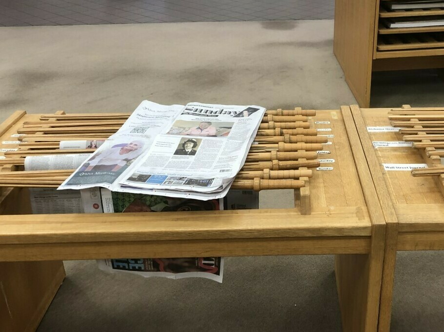 caption: A copy of <em>The Birmingham News</em> rests on a rack at the downtown public library in Birmingham, Ala. The company that runs the newspaper and two sister papers says it will permanently stop print publication after Feb. 26, 2023.