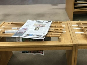 caption: A copy of <em>The Birmingham News</em> rests on a rack at the downtown public library in Birmingham, Ala. The company that runs the newspaper and two sister papers says it will permanently stop print publication after Feb. 26, 2023.