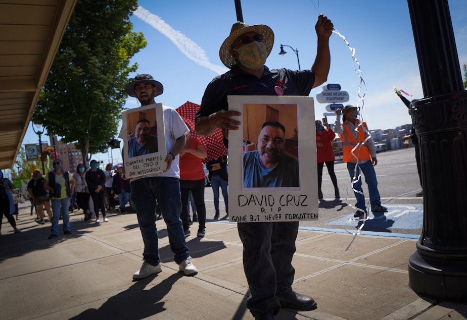 caption: Emmanuel Anguiano-Mendoza, left, and Agustin López hold posters featuring featuring David Cruz, a worker who died on May 30.Enrique Pérez de la Rosa/NWPB