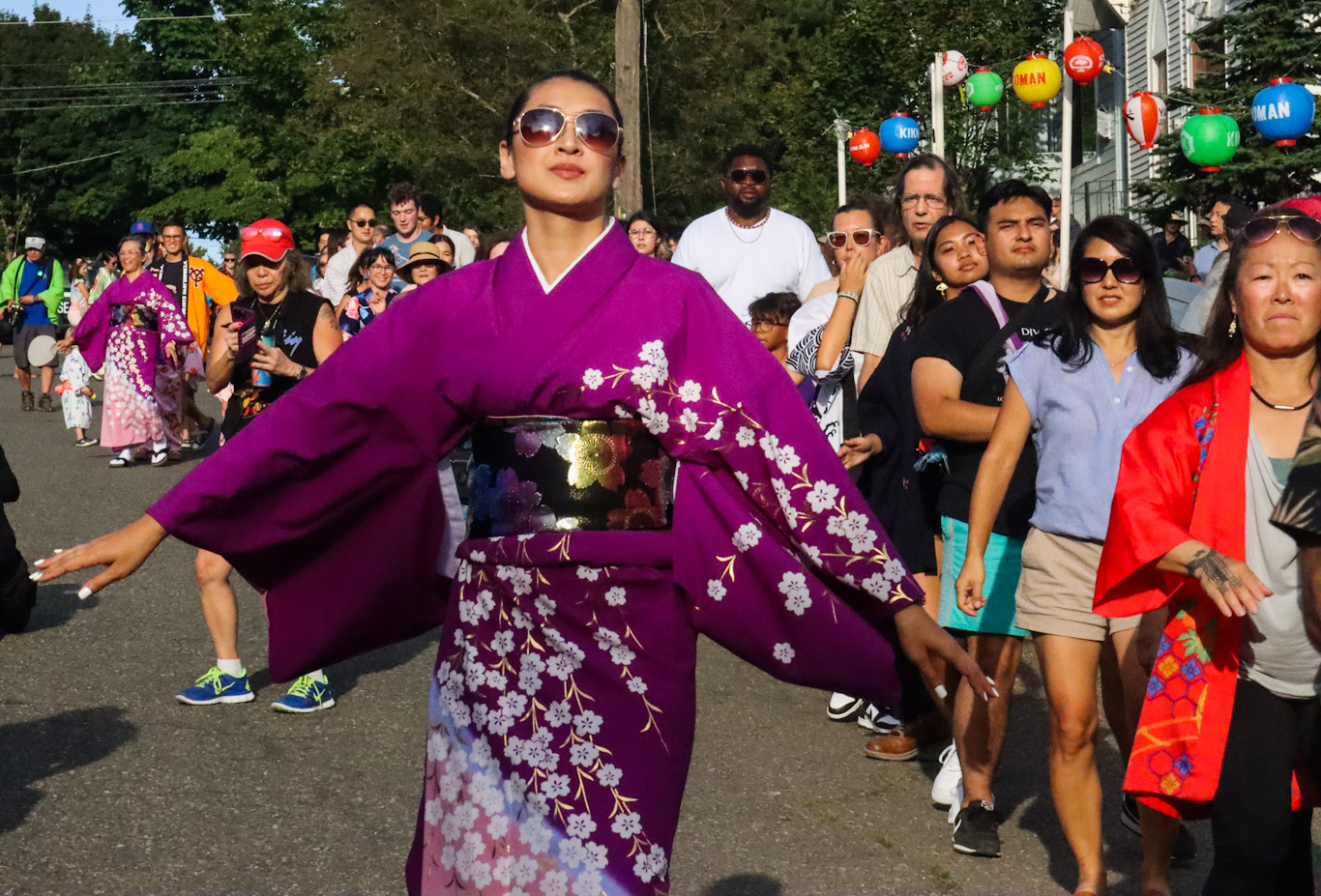 caption: A "dance leader" shows off her moves as the crowd follows along at the Bon Odori festival Saturday in Seattle's Chinatown-International District.