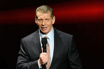 caption: WWE Chairman and CEO Vince McMahon speaks at a news conference in January 2014.