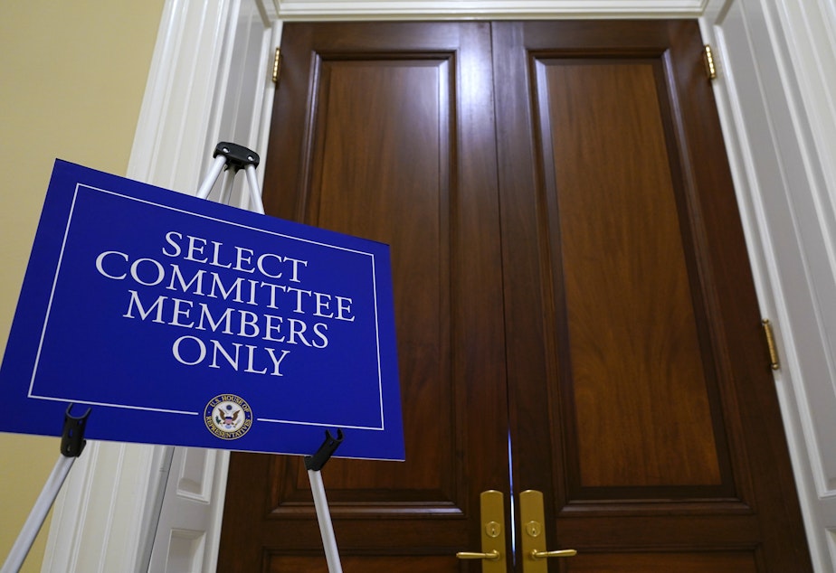 caption: The entrance to the room for the House select committee investigating the Jan. 6 attack is seen after the panel announced Monday it has scheduled a surprise hearing for Tuesday to present evidence it says it recently obtained.