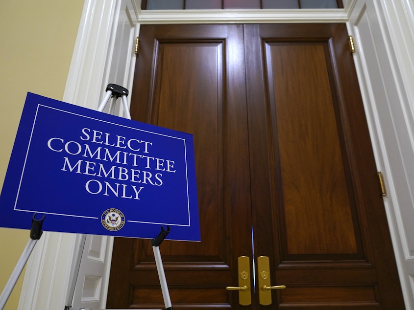 caption: The entrance to the room for the House select committee investigating the Jan. 6 attack is seen after the panel announced Monday it has scheduled a surprise hearing for Tuesday to present evidence it says it recently obtained.