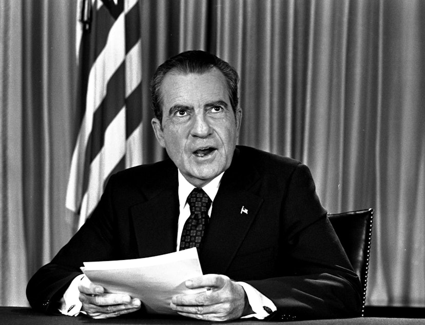 caption: President Nixon sits in his White House office, Aug. 16, 1973, as he poses for pictures after delivering a nationwide television address dealing with Watergate. (AP Photo)
