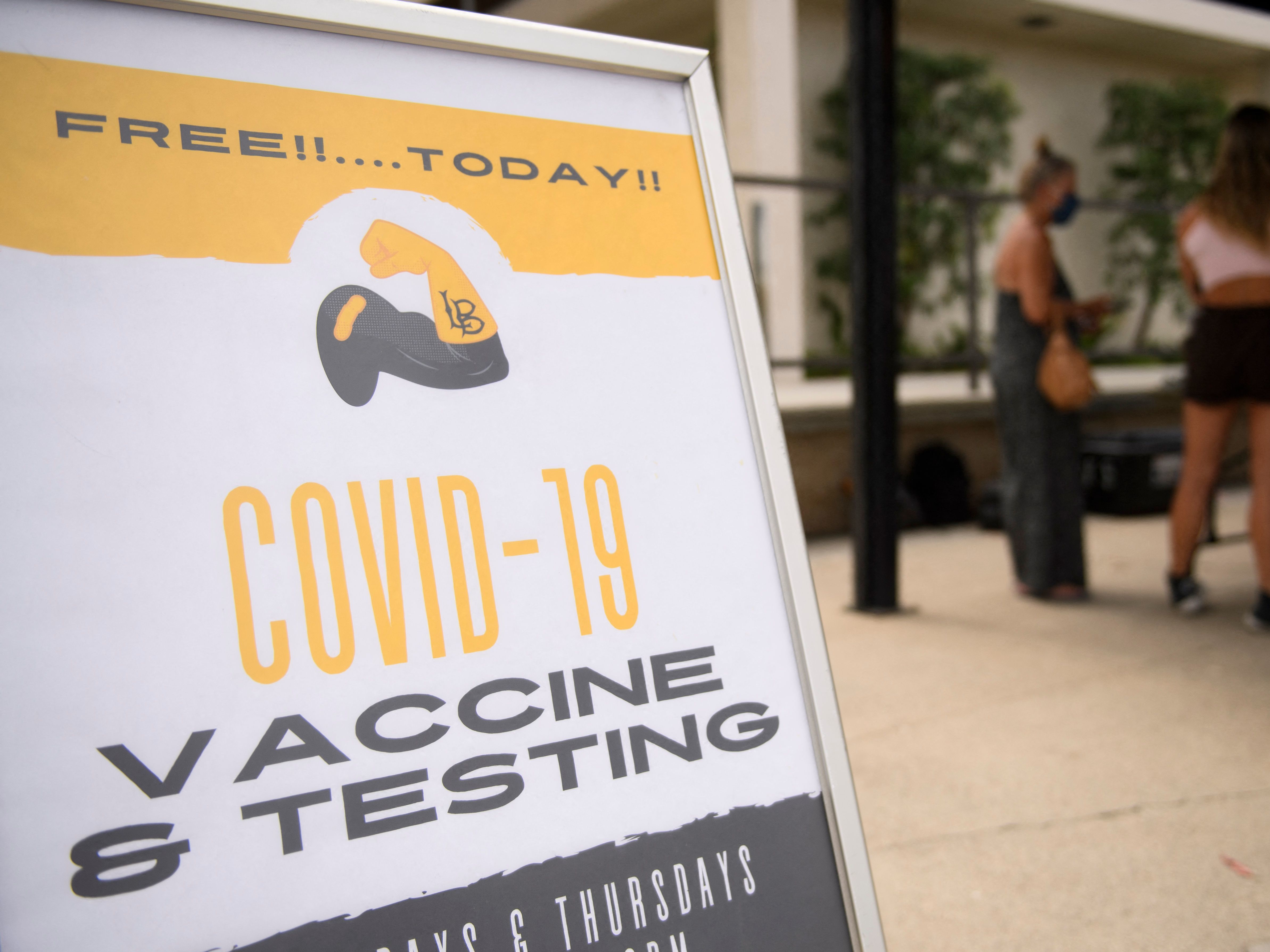 caption: Free Covid-19 vaccine and testing signage is displayed during a City of Long Beach Public Health Covid-19 mobile vaccination clinic at the California State University, Long Beach.