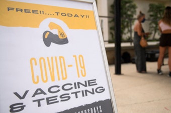 caption: Free Covid-19 vaccine and testing signage is displayed during a City of Long Beach Public Health Covid-19 mobile vaccination clinic at the California State University, Long Beach.