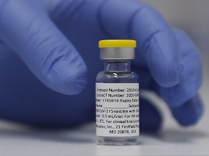caption: A vial of the experimental Novavax coronavirus vaccine is ready for use in a London study in 2020. Novavax's vaccine candidate contains a noninfectious bit of the virus — the spike protein — with a substance called an adjuvant added that helps the body generate a strong immune response.