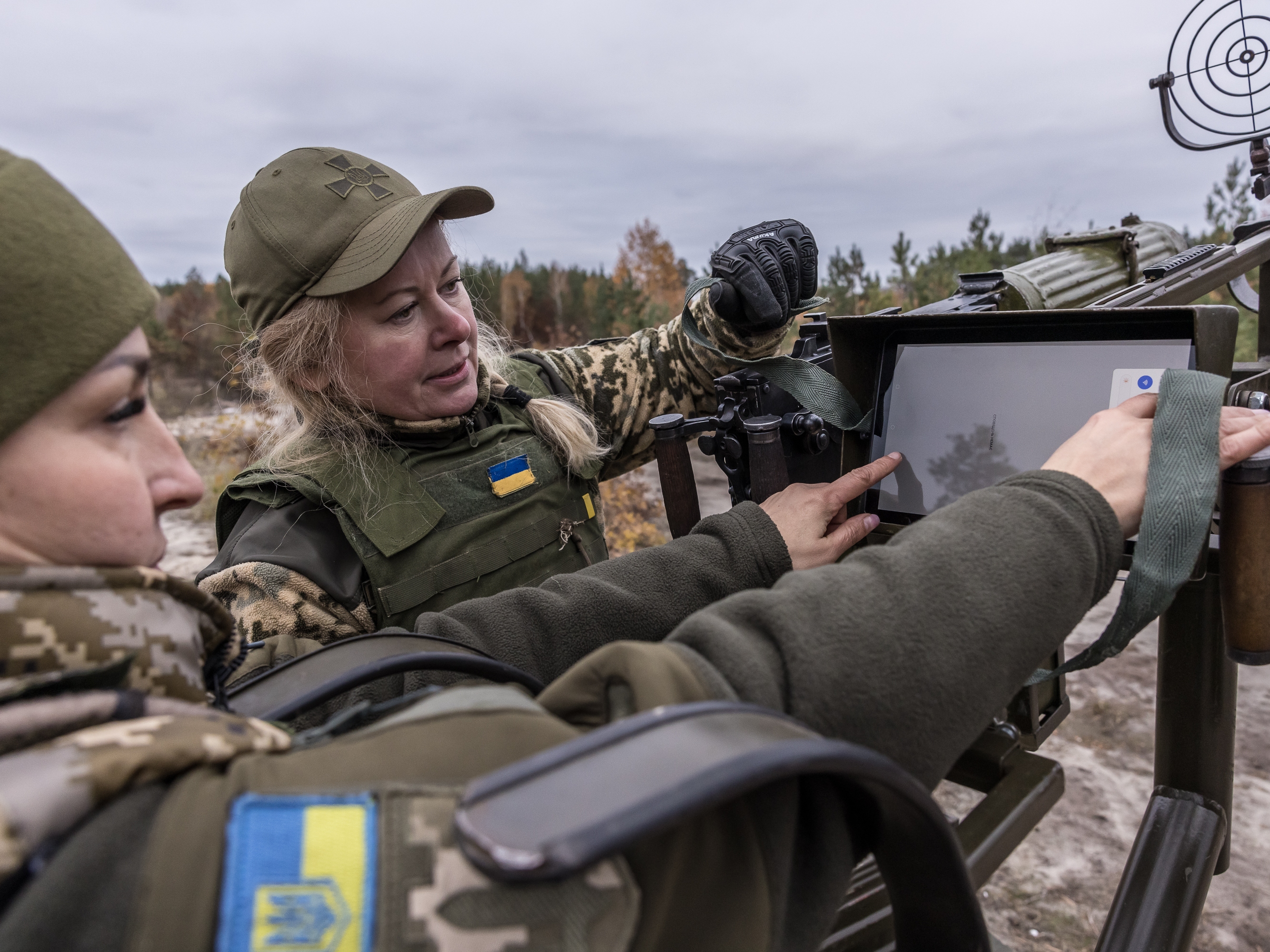 caption: Tetiana (left) and Olena, members of the female air defense unit known as the "Combat Witches of Bucha," assemble a Maxim machine gun during training in the Kyiv region, Ukraine