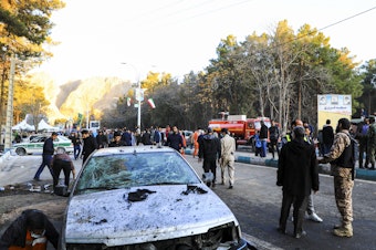caption: People gather at the site of an explosion in the city of Kerman, about 510 miles southeast of the capital Tehran, Iran, on Wednesday. Two bombs exploded at a commemoration for a prominent Iranian general slain by the U.S. in a 2020 drone strike, Iranian officials said.