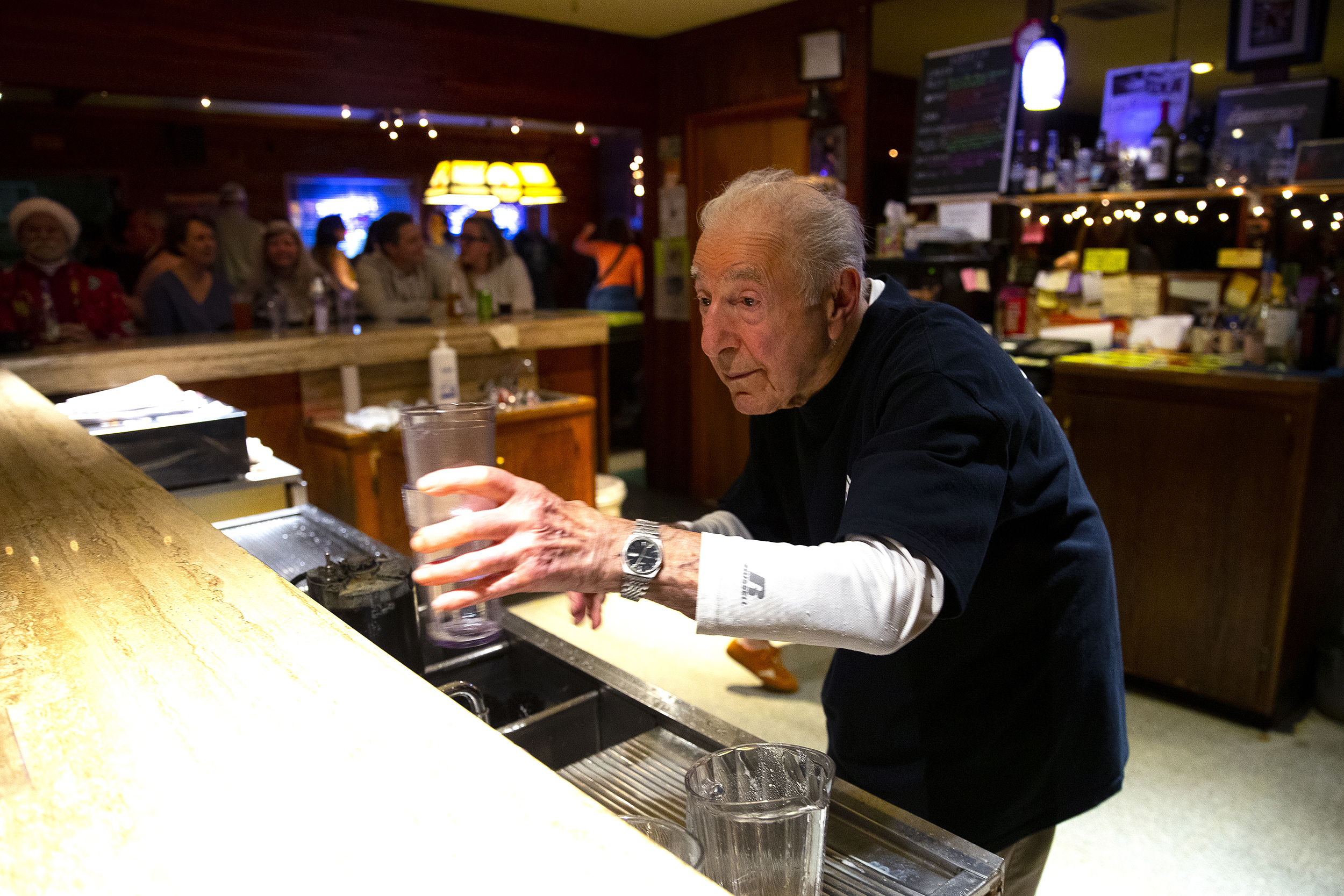 caption: John Spaccarotelli, 94-year-old owner and bartender at what many call the ‘last roadhouse in Seattle,’ tends bar on Friday, December 19, 2025, at the Shanty Tavern in Lake City. 
