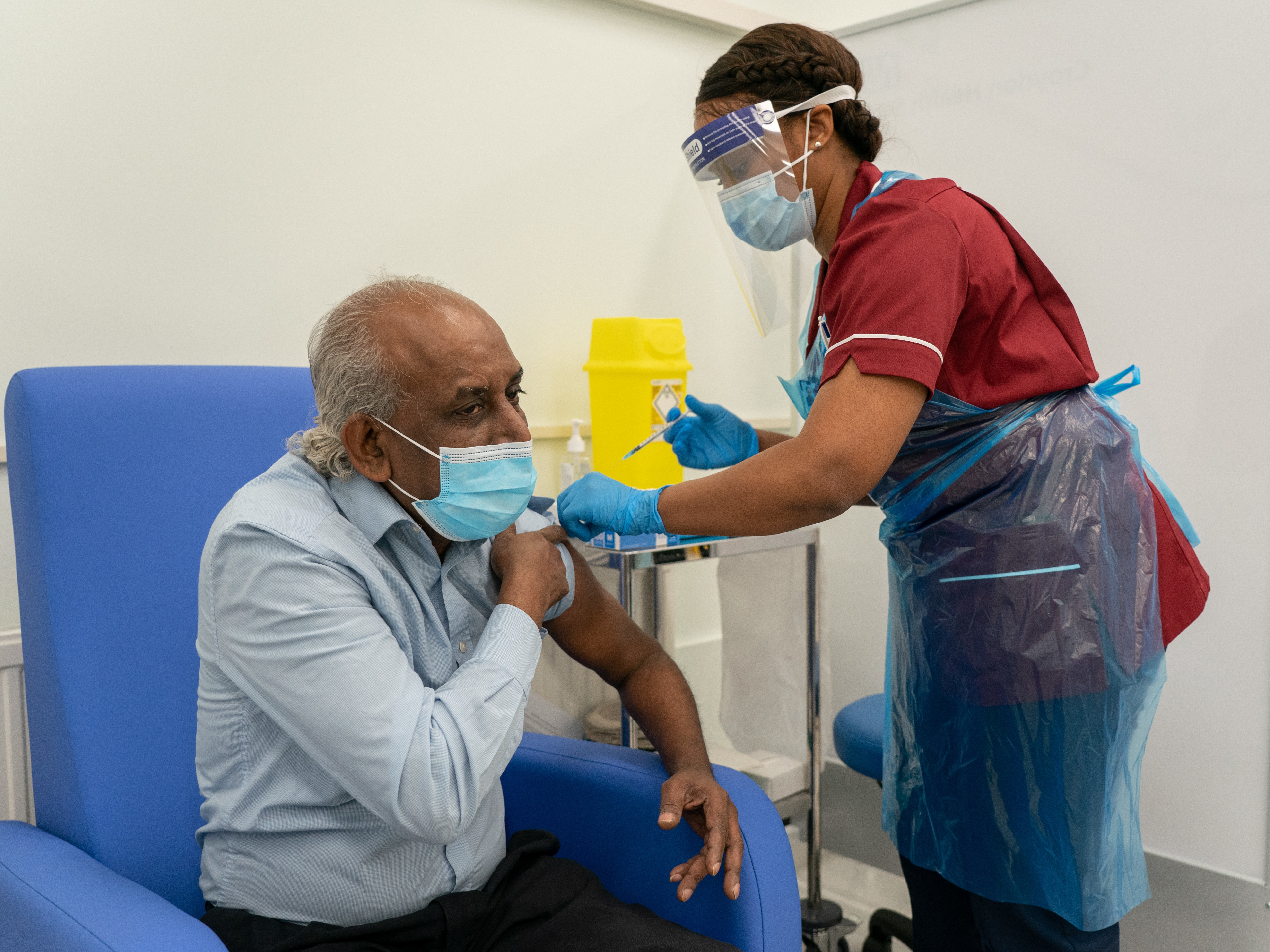 caption: A nurse prepares to administer a COVID-19 vaccine at Croydon University Hospital in London.