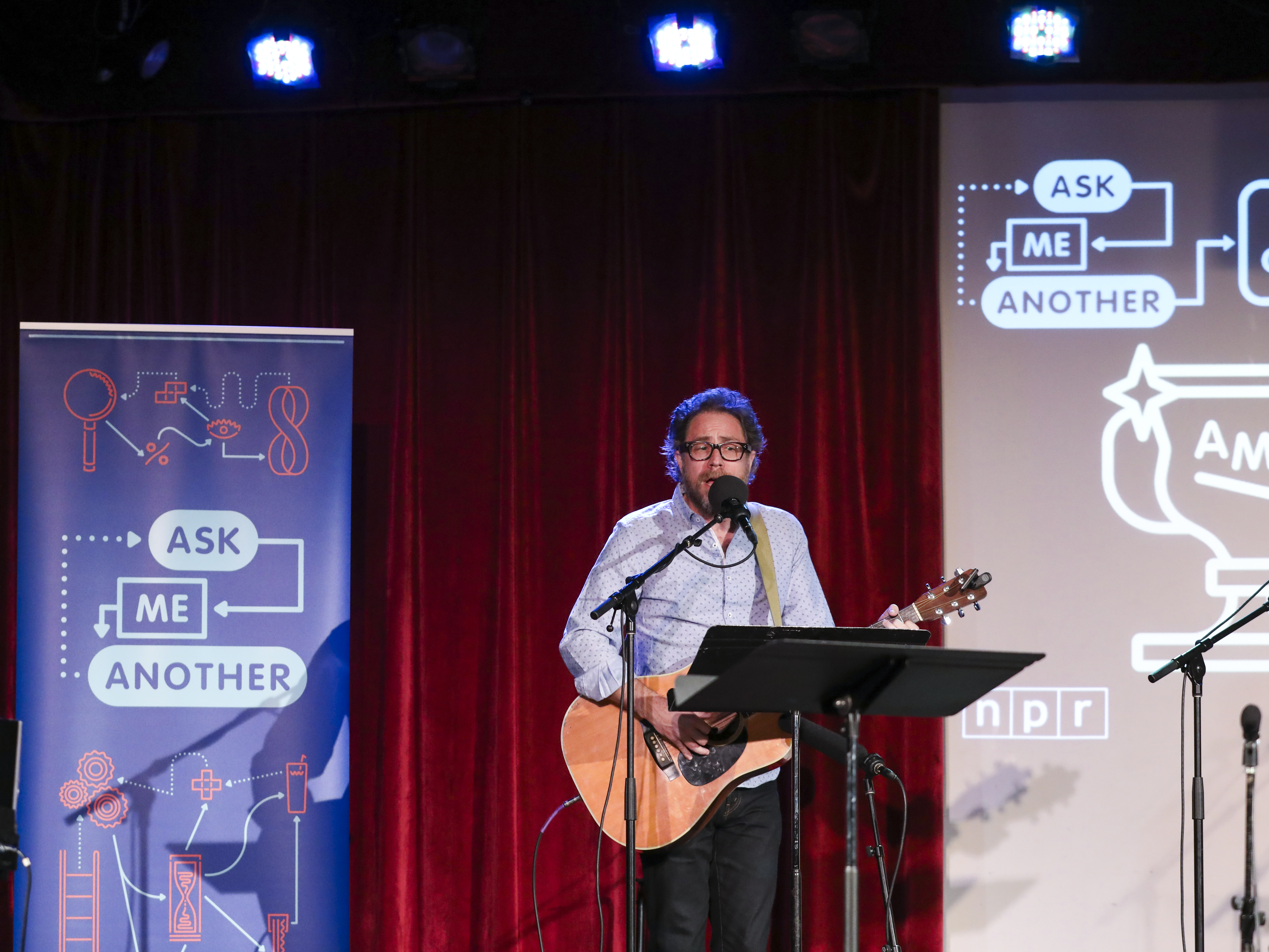 caption: <em>Ask Me Another'</em>s house musician Jonathan Coulton leads a music parody game at the Bell House in Brooklyn, New York.