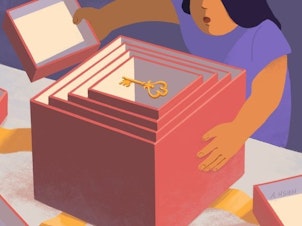 A woman opens a box that's filled with other, increasingly smaller boxes. Inside the smallest box, there's a key.