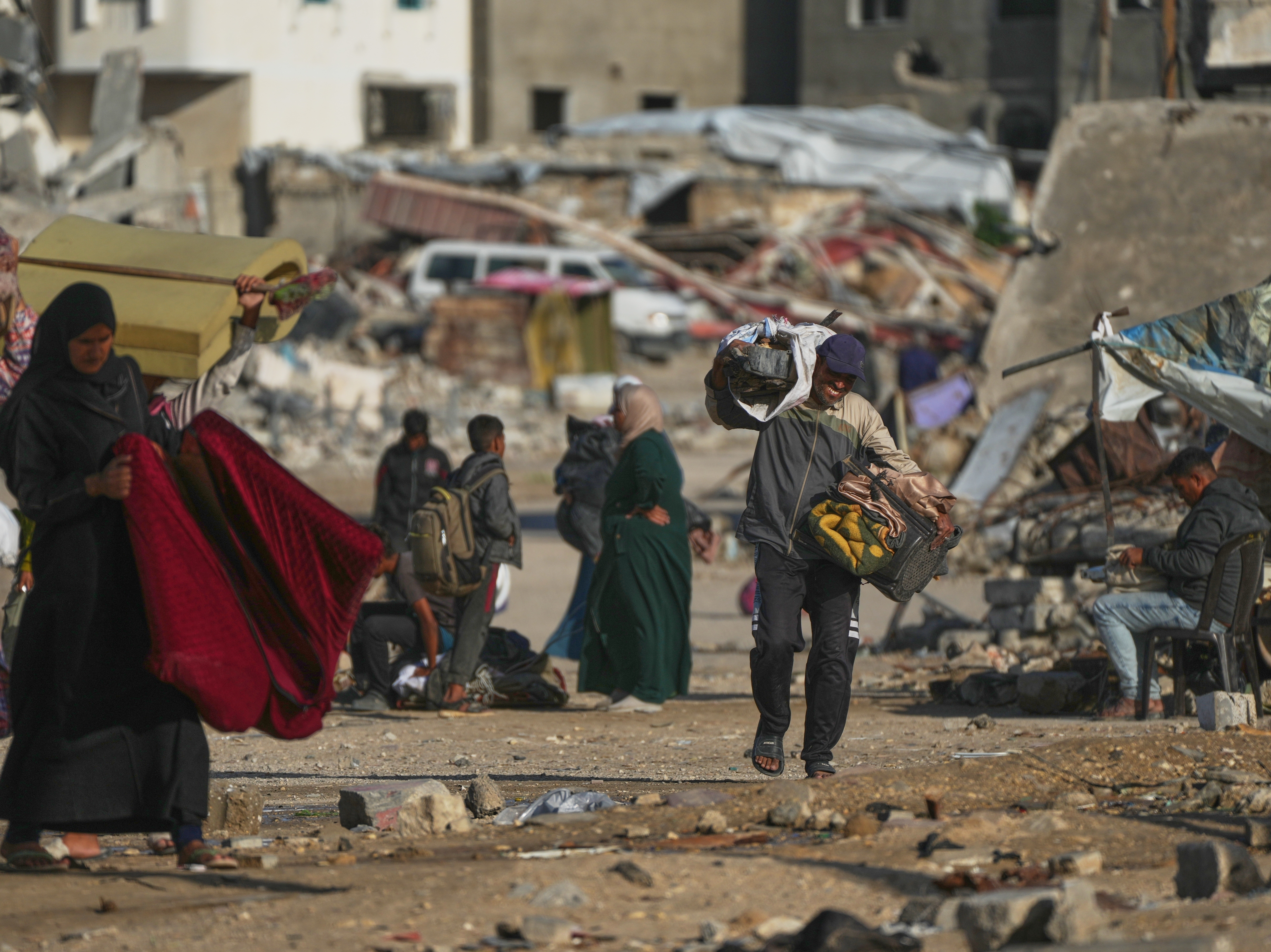 caption: A Palestinian man carries bags of firewood after collecting it from the rubbish in Khan Younis, southern Gaza Strip, on Saturday.