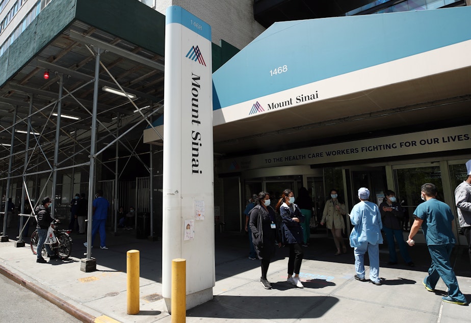caption: A view of the entrance to Mount Sinai Hospital in New York City on May 14, 2020. Hospital and nursing home workers across New York are required to have at least one dose of a COVID-19 vaccine by Monday, prompting concerns over noncompliance and potential staffing shortages.