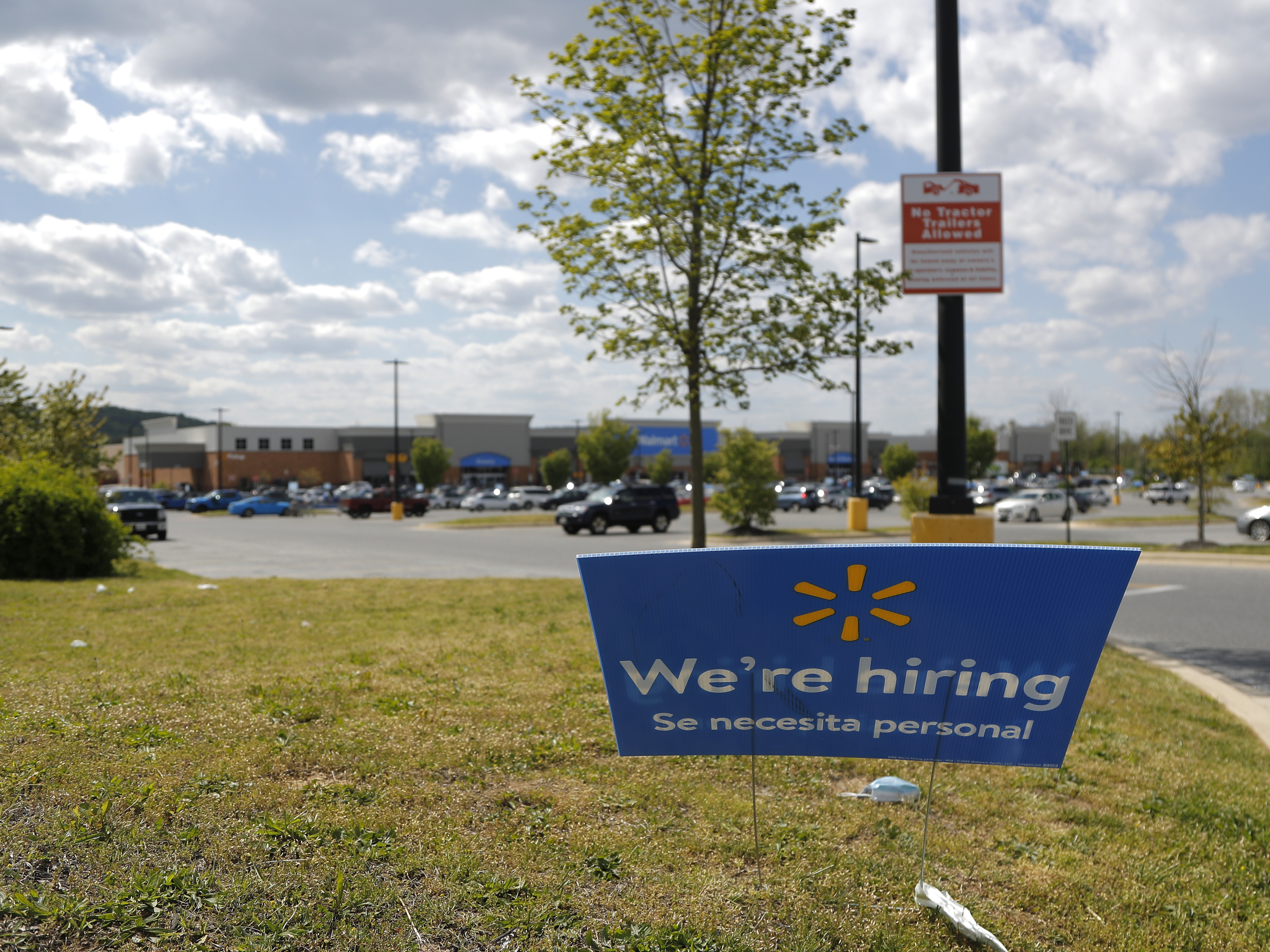 caption: A Walmart store in Maryland advertises its hiring during the coronavirus pandemic. The big retailer says it hired 235,000 new staffers to keep up with demand.