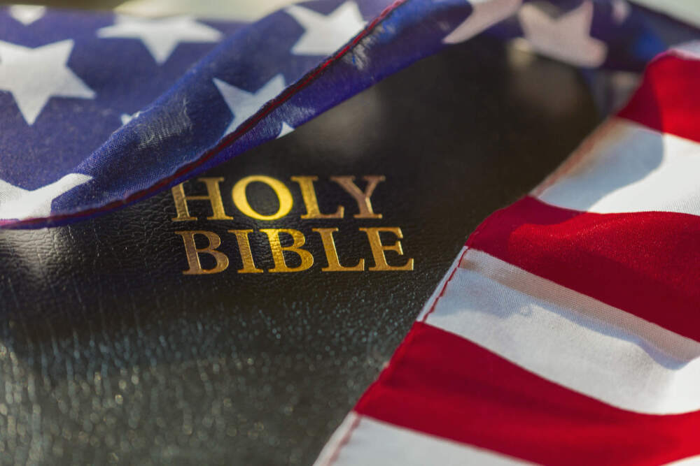 caption: The Holy Bible is draped with an American flag. (Eric Raptosh/Getty Images)