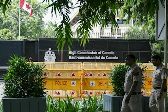 caption: Security personnel outside the High Commission of Canada in New Delhi. Both India and Canada have expelled a diplomat as part of escalating tensions over the death of a Sikh activist in British Columbia in June.