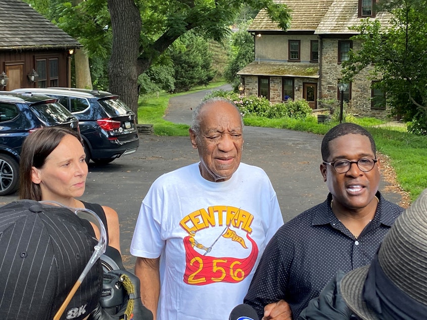 caption: Attorney Jennifer Bonjean, Bill Cosby, and spokesperson Andrew Wyatt speaking outside of Cosby's suburban Philadelphia home in June, after the actor was released from prison.
