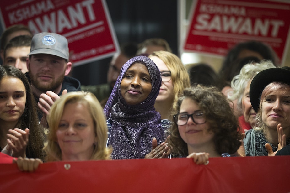 caption: Supporters including Ubah Warsame-Aden, center, clap for Seattle City Councilmember Kshama Sawant during a press conference on Saturday, November 9, 2019, at Langston Hughes Performing Arts Institute in Seattle.