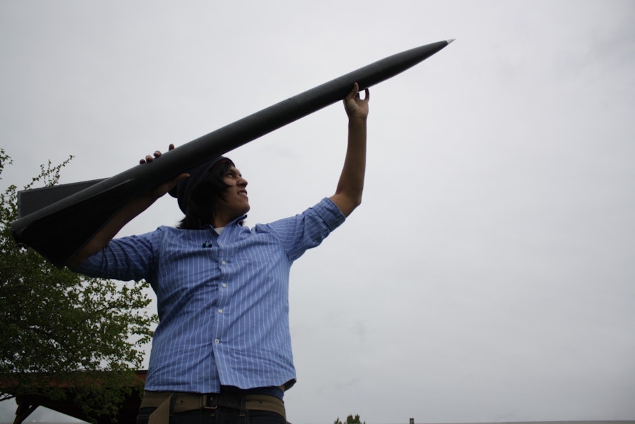 caption: Chris Cultee, a student at the Northwest Indian College, with a rocket that broke the sound barrier.