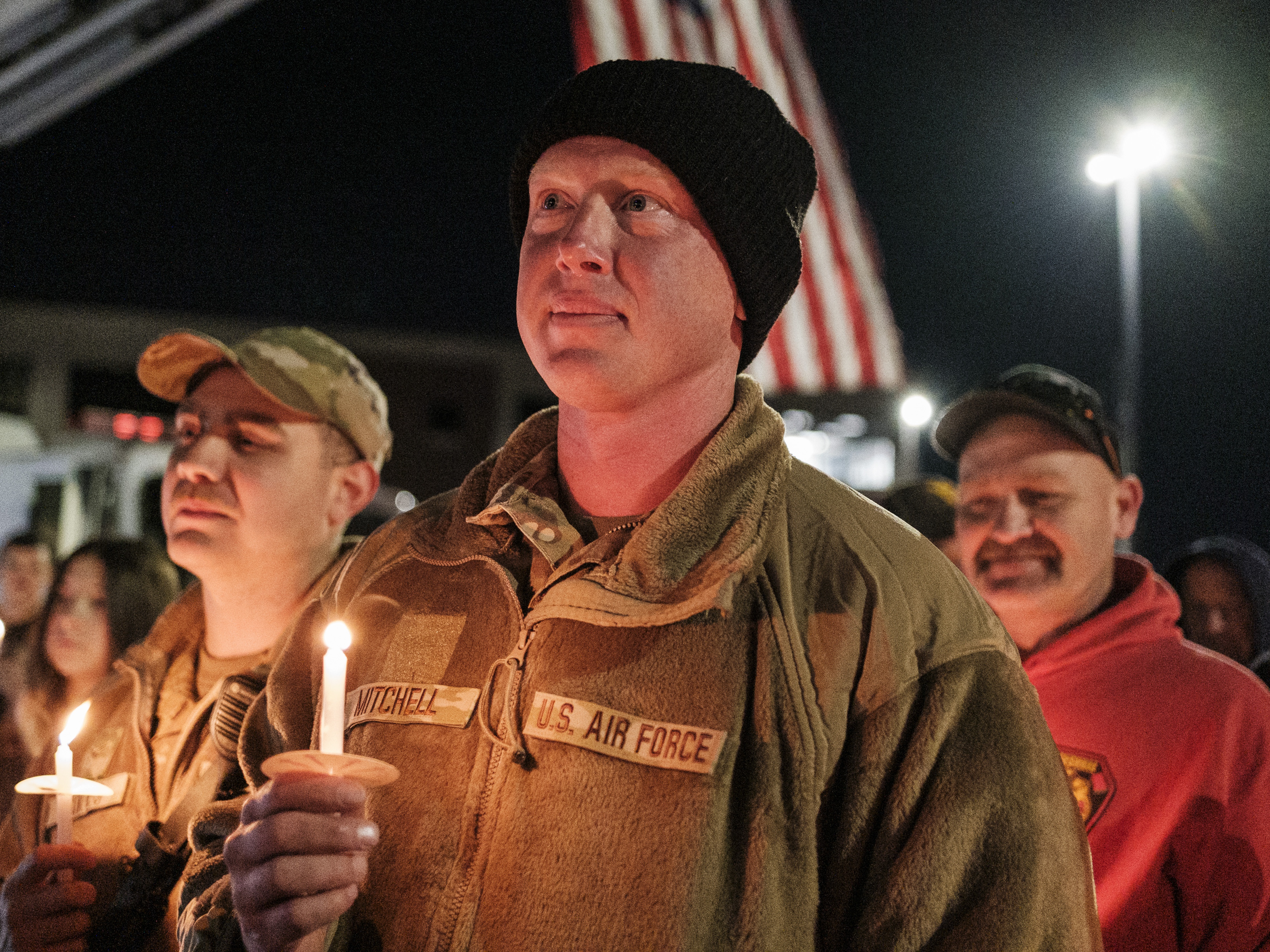 caption: Staff Sgt. Jason Mitchell, a member of the West Virginia Air National Guard, attends a candlelight vigil for Staff Sgt. Andrew Wolfe outside the  Berkeley County Sheriff's office on Wednesday in Martinsburg, W.Va. Wolfe was shot near the White House on Nov. 26 in what officials described as a targeted attack by an Afghan refugee who had previously worked with the U.S. military and CIA in Afghanistan.