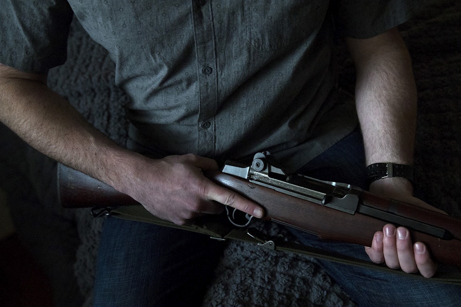 caption: Josh Young holds his M1 Garand firearm on Friday, February 21, 2020, at his home in Seattle. 