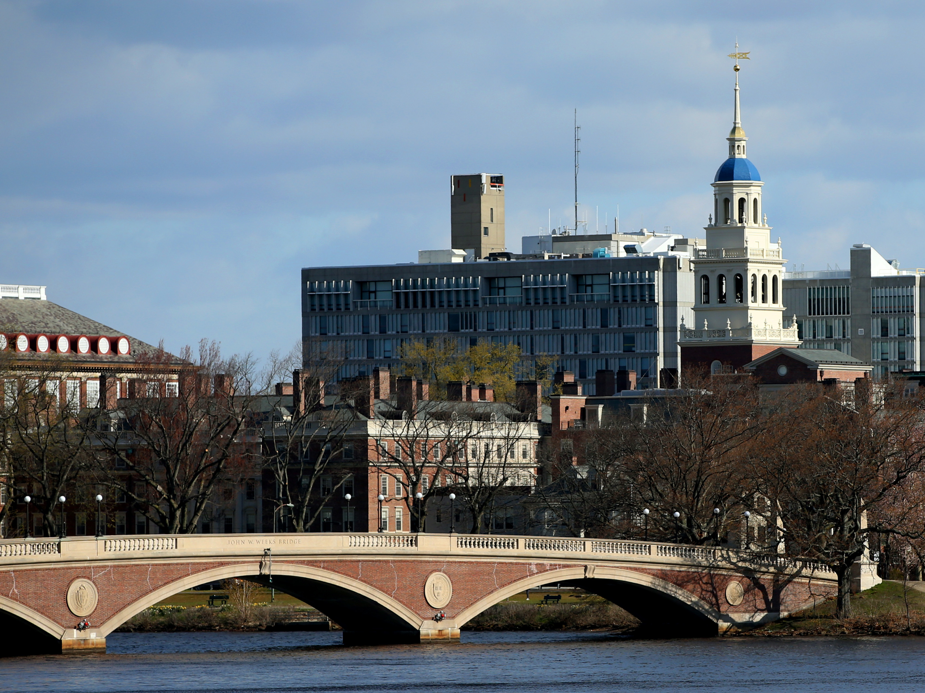 caption: Harvard University in Cambridge, Mass., pictured in April 2020. President Lawrence Bacow said Thursday that it will move to end its investments in fossil fuel companies, though stopped short of using the word "divest."