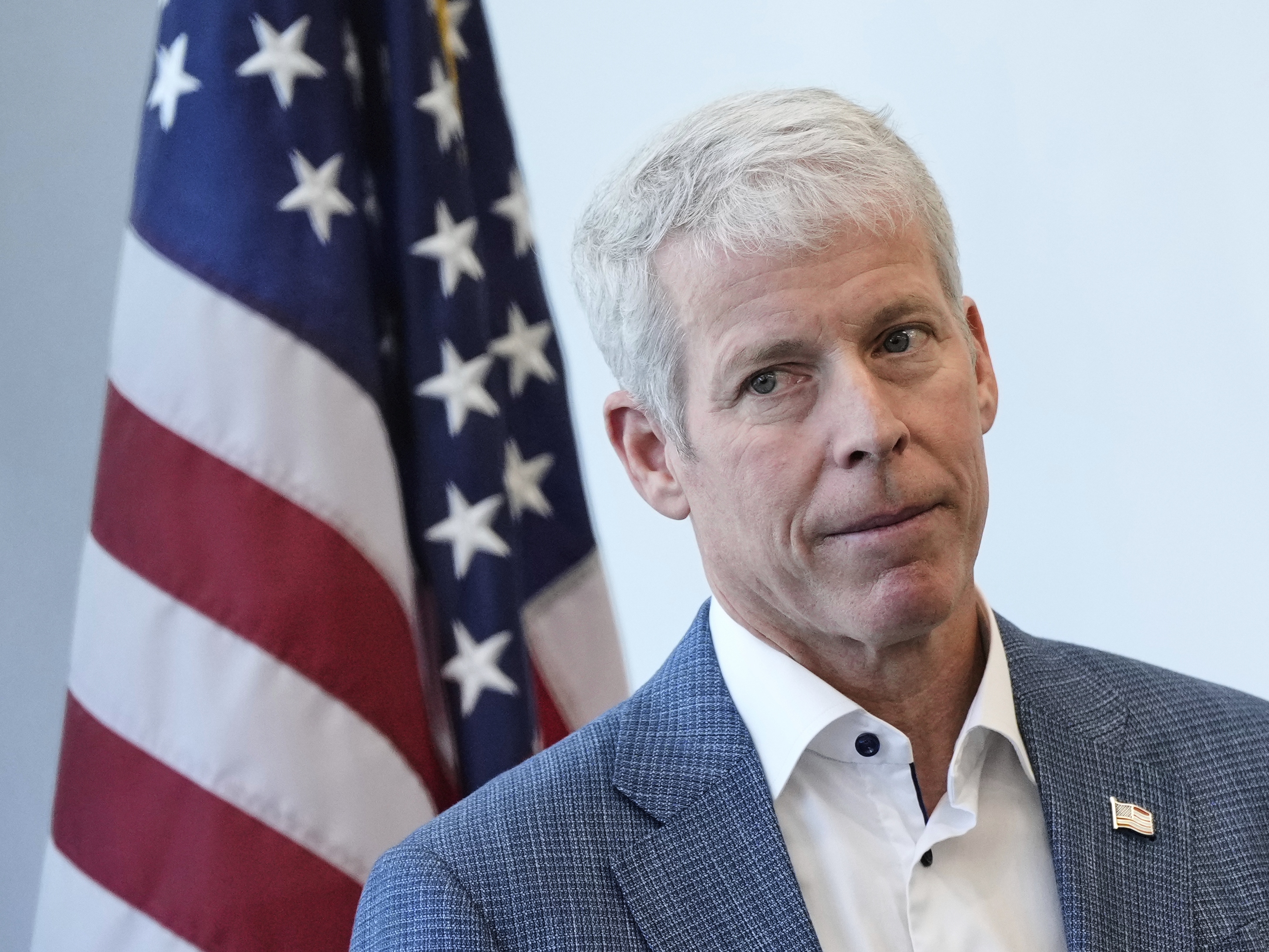 caption: Secretary of Energy Chris Wright listens during a press conference this spring at Lawrence Berkeley National Laboratory in California.