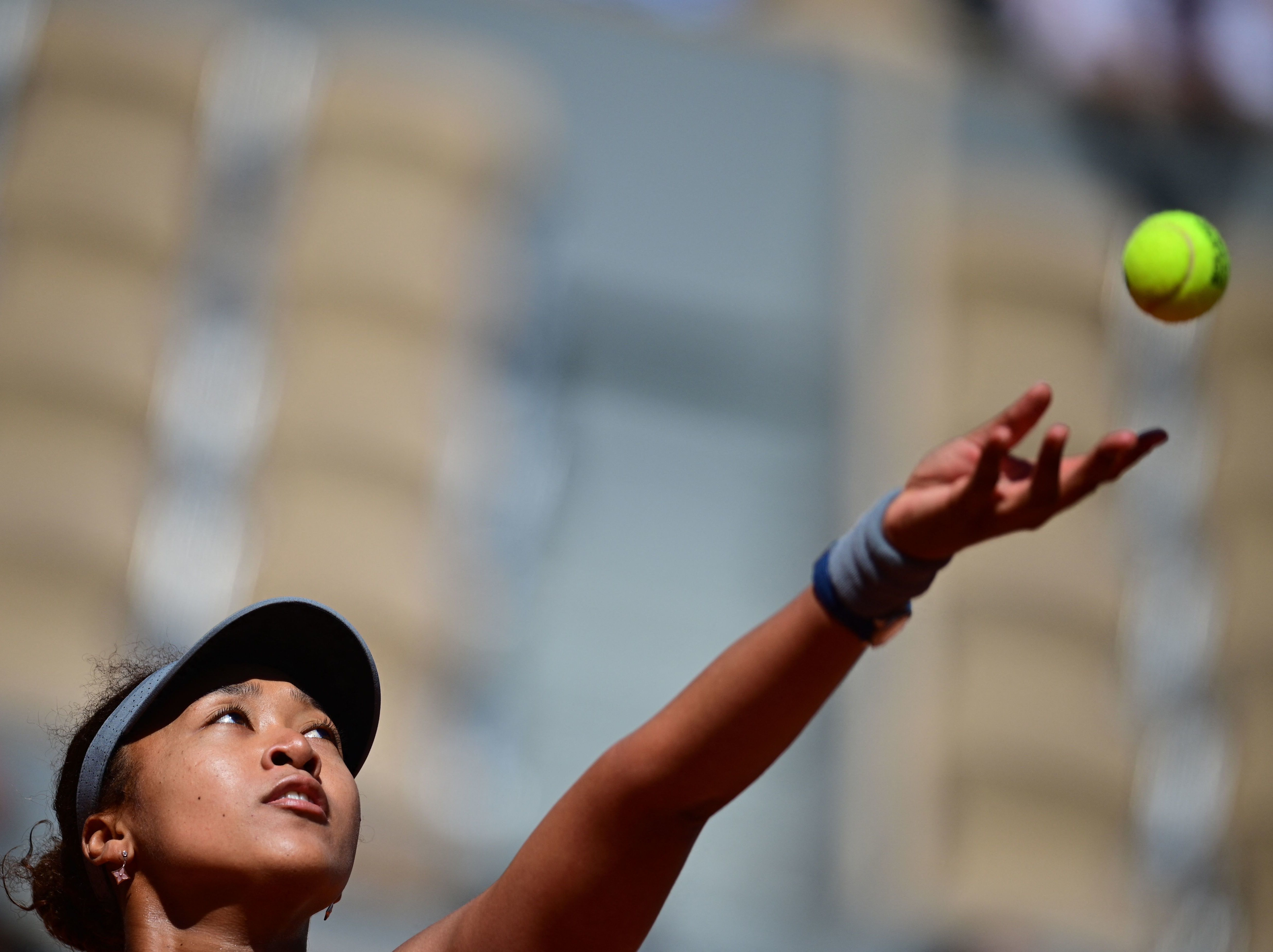 caption: Japan's Naomi Osaka eyes the ball as she serves during the first round of the French Open tennis tournament in Paris on Sunday.