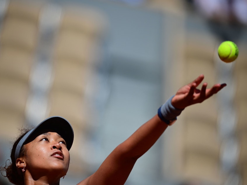 caption: Japan's Naomi Osaka eyes the ball as she serves during the first round of the French Open tennis tournament in Paris on Sunday.