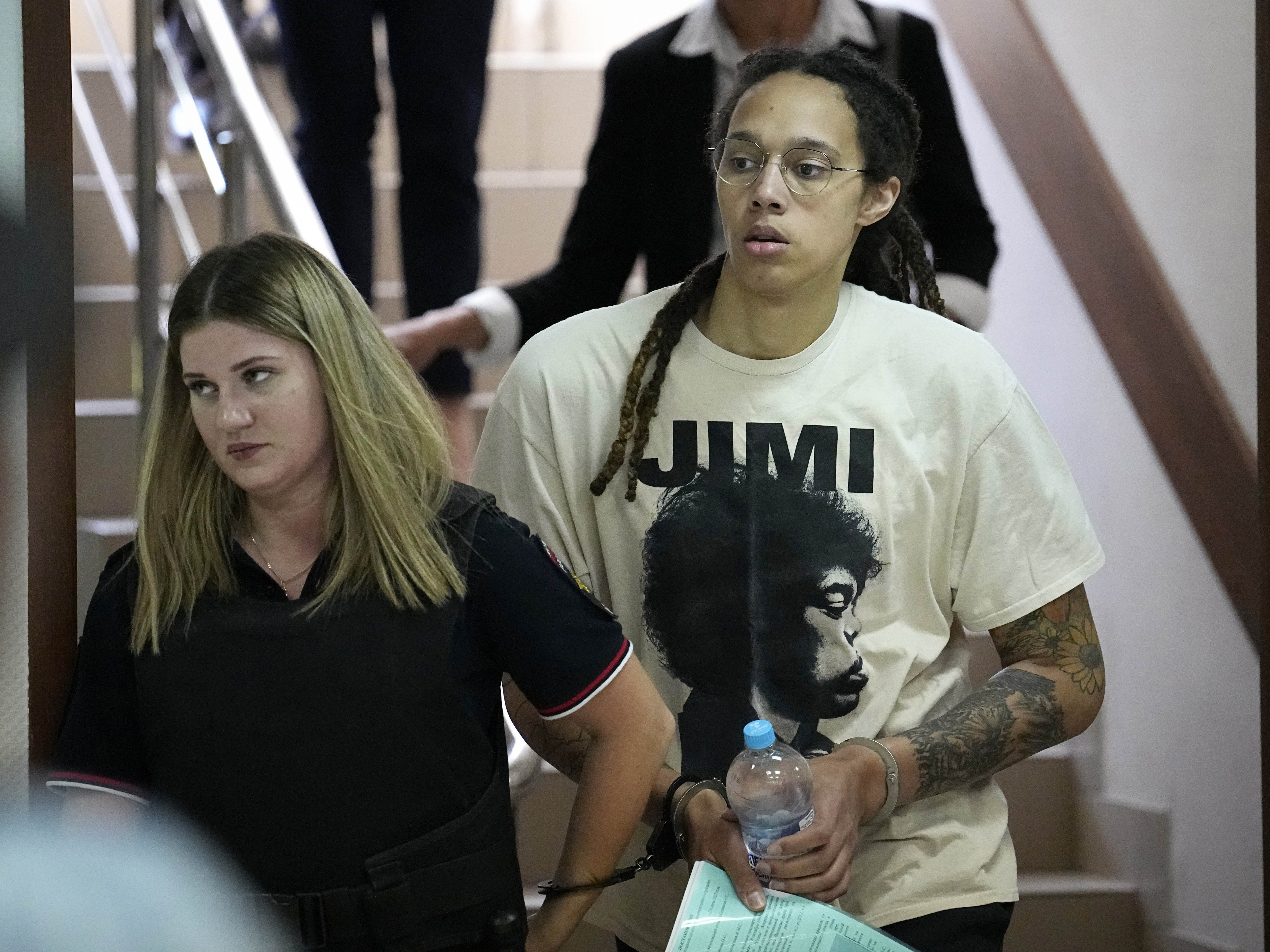 caption: WNBA star and two-time Olympic gold medalist Brittney Griner is escorted to a courtroom for a hearing, in Khimki just outside Moscow, Russia, Friday, July 1, 2022.