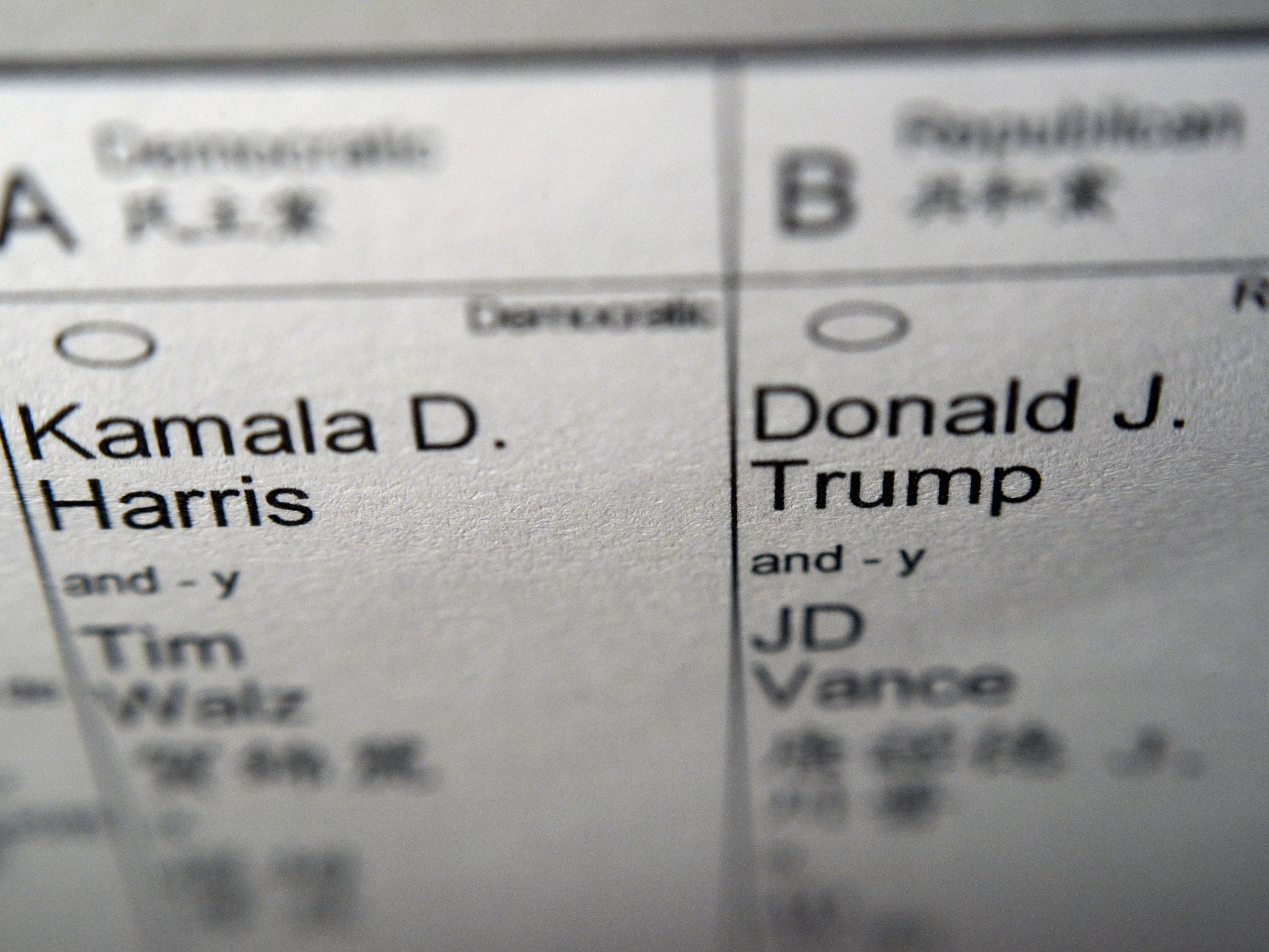 caption: Candidates for president and vice president of the United States, Democrats Vice President Kamala Harris and Minnesota Gov. Tim Walz, and Republicans former President Donald Trump and Sen. JD Vance, R-Ohio, are seen on part of a mail-in election ballot in New York on Sunday.