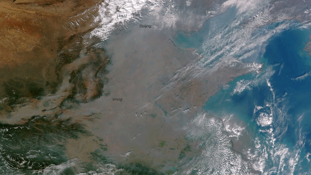 caption: A satellite image of smog over China. Westerly winds can carry air pollution from China across the Pacific Ocean in just a few days. A new study is linking air pollution in the Western United States to China’s booming exports. 