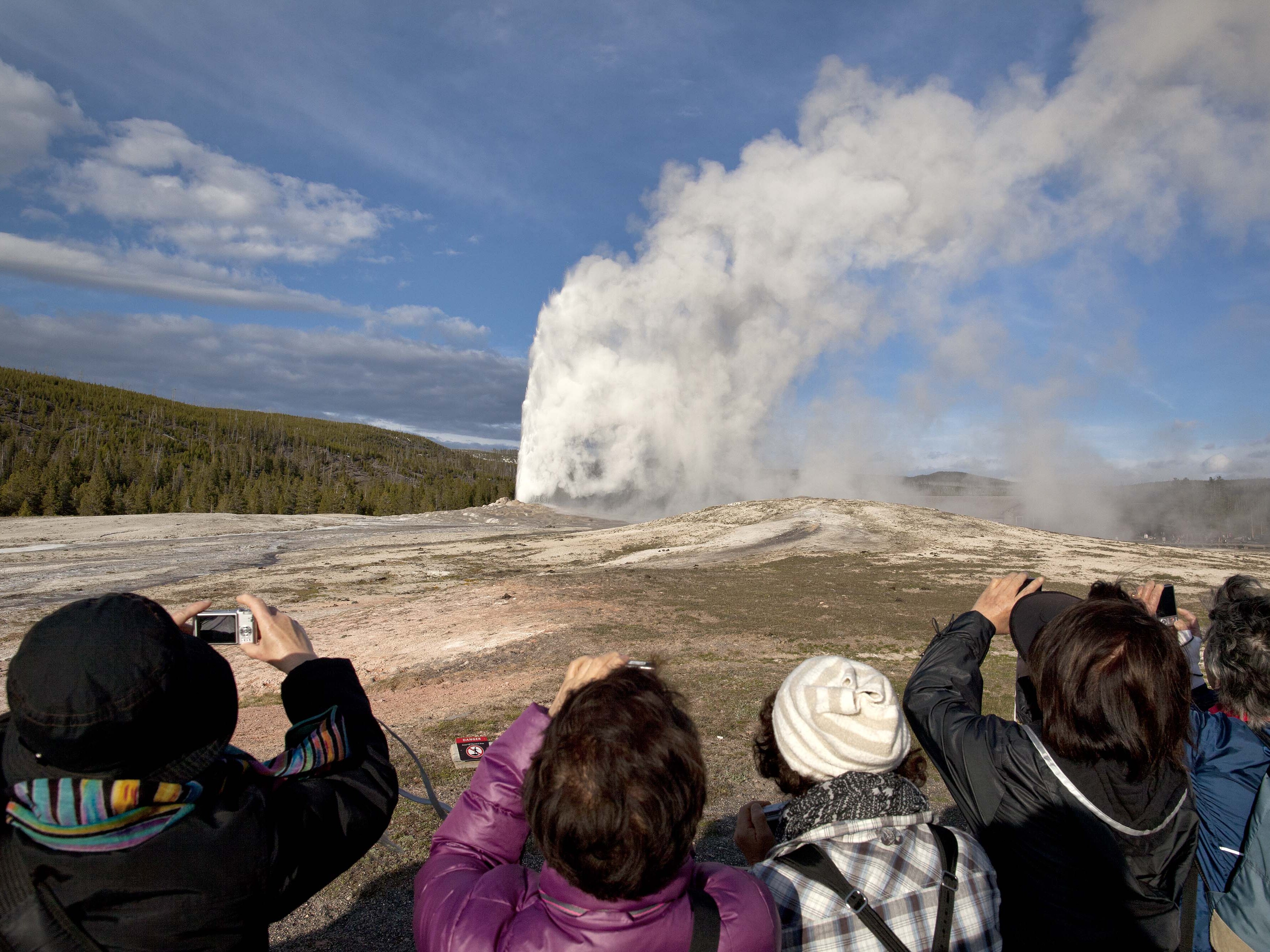 caption: Tourists are seen photographing an eruption of Old Faithful at Yellowstone National Park in this 2011 file photo. On Thursday, a man was killed in an exchange of gunfire with law enforcement park rangers after he was reported to have a weapon and issuing threats, according to the National Park Service.