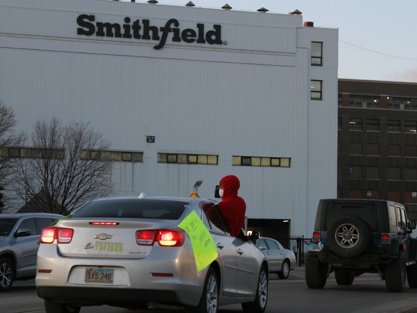 caption: Employees and family members protest outside a Smithfield Foods processing plant in Sioux Falls, South Dakota last week. The plant has had an outbreak of coronavirus cases.