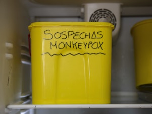 caption: A bucket with suspected monkeypox samples is stored at a laboratory in Spain in June.
