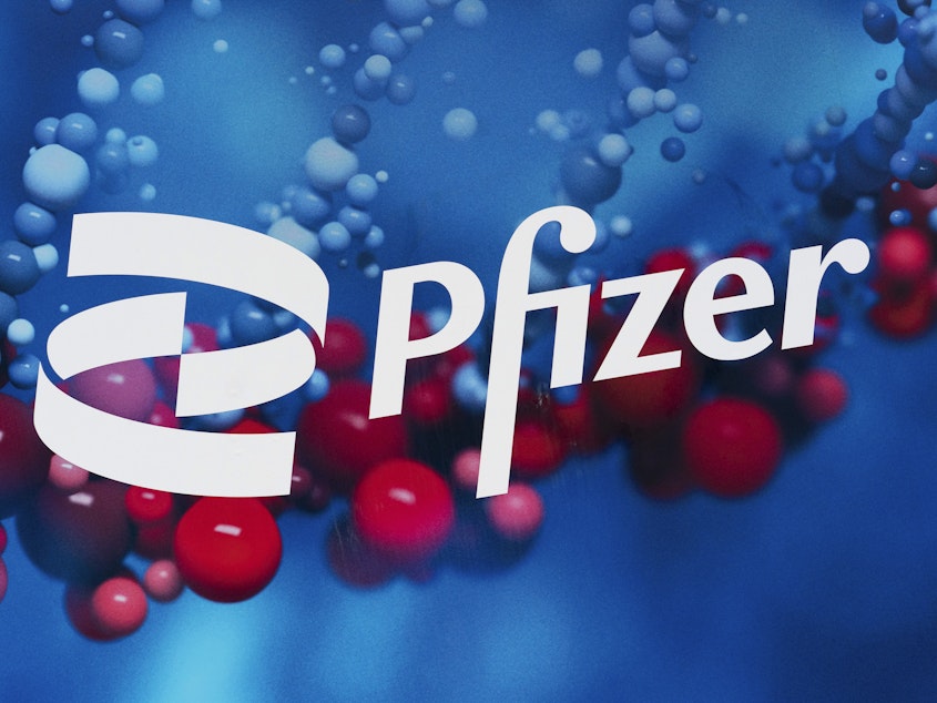 caption: The Pfizer logo is displayed at the company's headquarters in New York. Pfizer says its experimental pill for COVID-19 cut rates of hospitalization and death by nearly 90% among patients with mild-to-moderate infections.