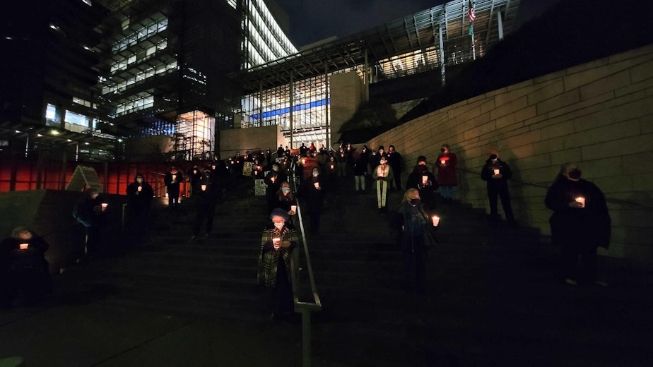 caption: People gathered at Seattle City Hall on December 21, 2021 to remember homeless people who died in the past year.