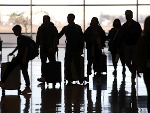caption: People pass through Salt Lake City International Airport on Wednesday. The outage of a key safety system led to thousands of flight delays and cancellations in the U.S.