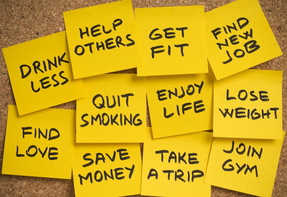 group of sticky yellow adhesive note papers with a list of new year's resolutions on the bulletin board