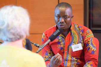 caption: Floribert Mubalama speaks with Julia Donk about his experiences as an immigrant on July 22, 2017 as part of KUOW's Ask An Immigrant event.
